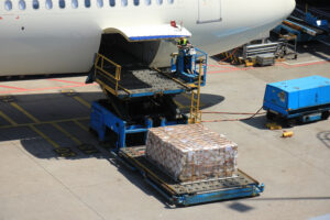 cargo getting loaded onto a parked aircraft on the pavement
